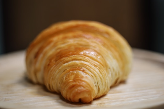 Les croissants sont placés sur un fond en bois des produits de boulangerie sur fond isolé