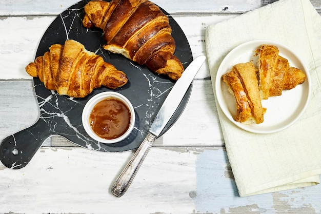 Photo croissants sucrés frais avec confiture d'orange pour le petit-déjeuner petit-déjeuner continental sur table en bois vue sur le dessus