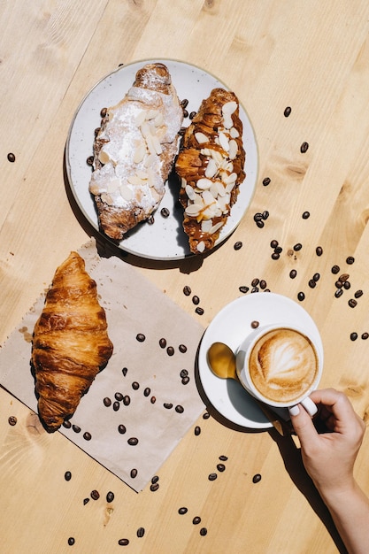 Photo des croissants et une tasse de café sur fond brun