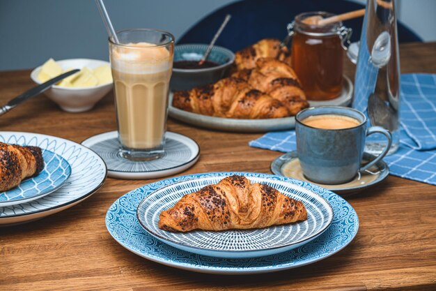 Croissants avec une tasse de café sur une table en bois.