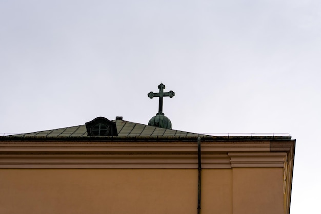 Croix au sommet de la cathédrale catholique par temps nuageux