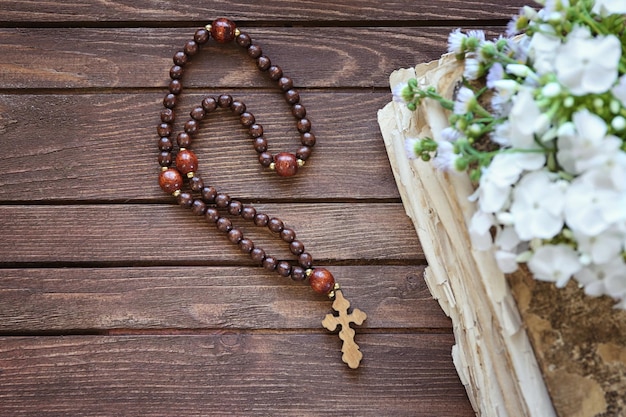 Croix en bois avec fleurs et vieux livre libre