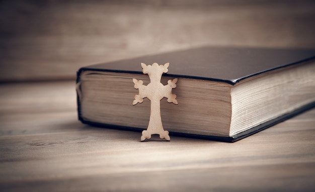 Croix chrétienne et Bible sur le fond en bois.