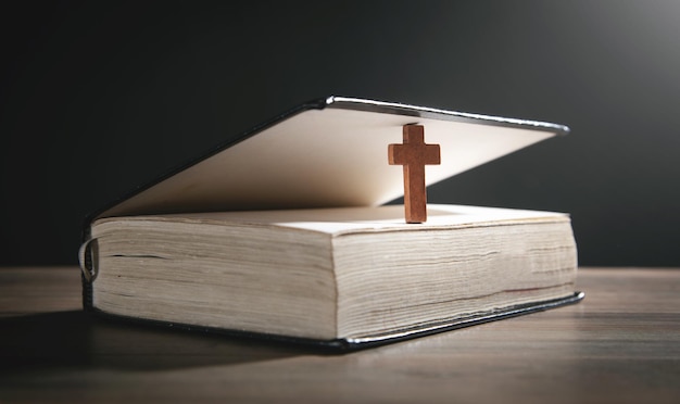 Croix chrétienne et Bible sur le fond en bois.