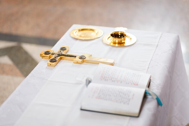 Croix, coupe et bible préparés pour la cérémonie de mariage