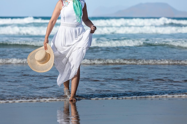 Crop femme marchant dans les vagues de la mer