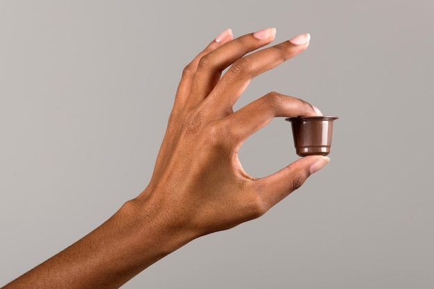 Crop femme noire avec une capsule de café à la main