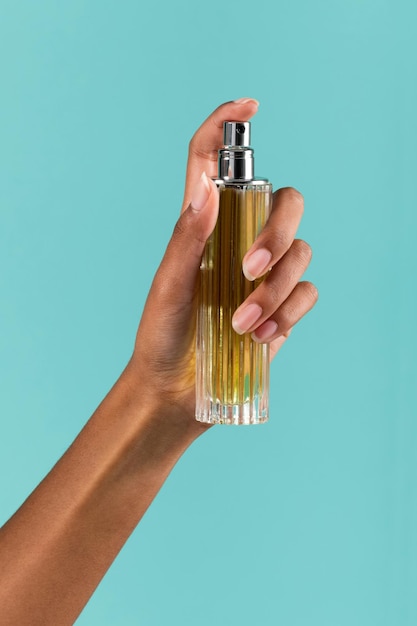 Crop femme noire pulvérisant du parfum