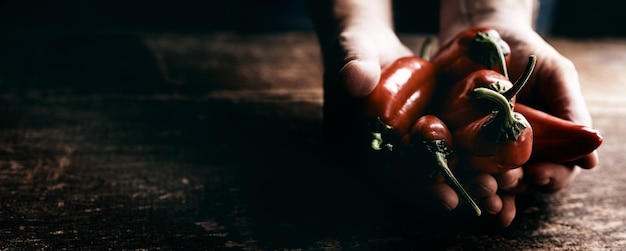 Crop personne avec des piments rouges à table