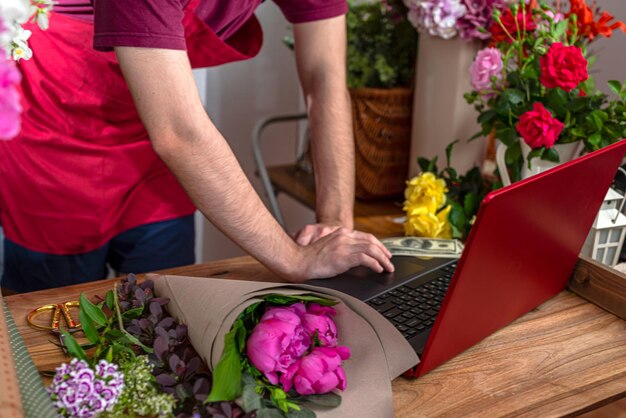 Crop view saller de fleurs. Entreprise de fleuriste. Composition de bouquets.