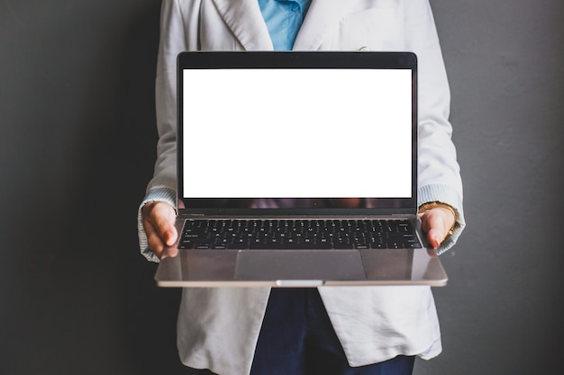 Cropped shot of business woman holding laptop avec écran blanc noir pour maquette