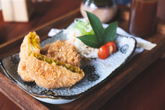 Croquette coupée en deux et légume sur table