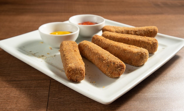 Croquette de pois chiches et sauces végétaliennes sur une assiette blanche sur une mise au point sélective en bois