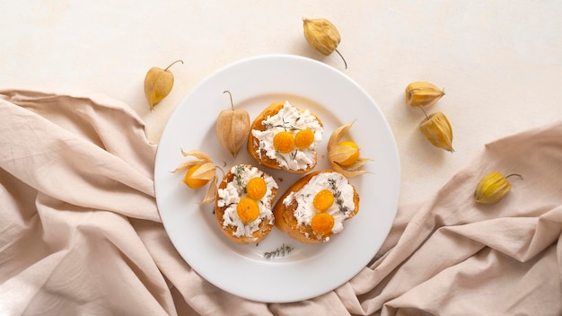 Crostini à la ricotta avec fruits physalis sur une plaque blanche