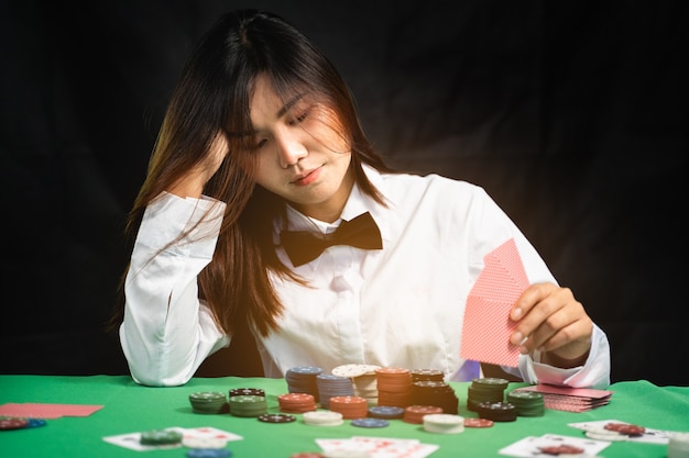Croupier ou croupier féminin mélange les cartes de poker dans un casino