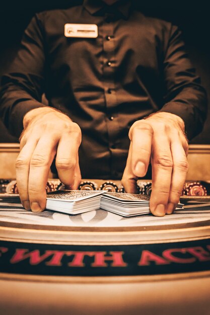 Photo le croupier mélange les cartes de poker dans un casino sur le fond de jetons de table