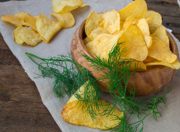 Croustillant de croustilles à l&#39;aneth dans un bol en bois sur une serviette en lin