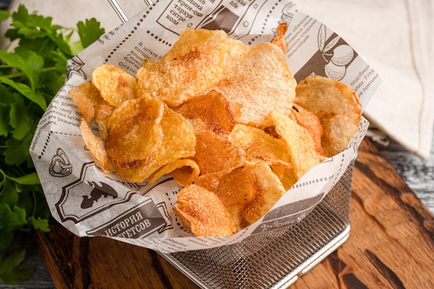 Croustilles de bière de pomme de terre frites sur un fond blanc en bois