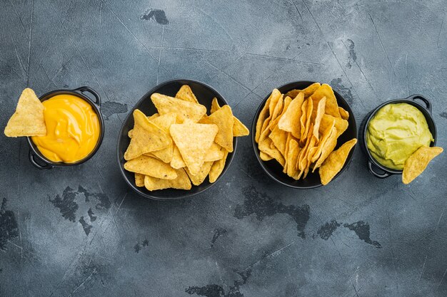 Croustilles de maïs nachos avec sauce trempette traditionnelle, sur table grise, vue de dessus ou mise à plat