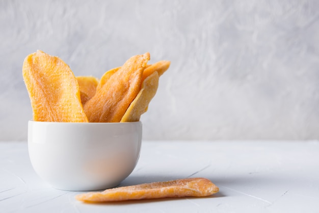 Croustilles de mangue séchées sur blanc. Fermer.