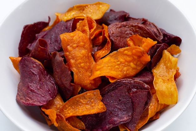 Croustilles de patates douces violettes et jaunes dans un bol