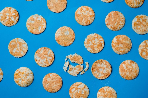 Croustilles de riz rond sur un fond de papier bleu