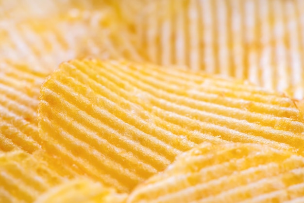 Croustilles striées croustillantes jaunes close up Food background