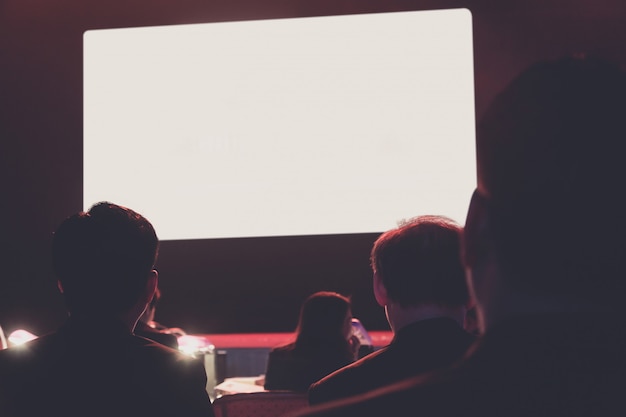 Photo crown regarde un moniteur blanc. public dans la salle de conférence. affaires et entrepreneuriat.