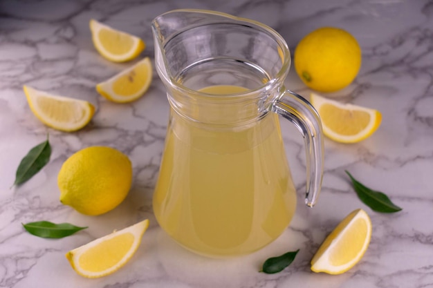 Une cruche de jus de citron sur un fond de marbre blanc Vue de dessus