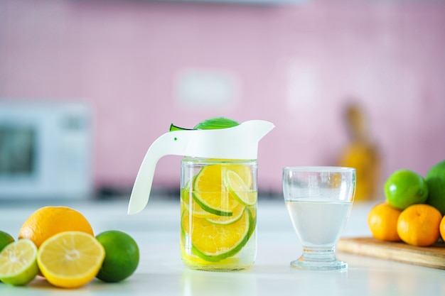 Cruche en verre avec de l'eau de citron détoxifiante infusée rafraîchissante pour une boisson de désintoxication vitaminée.