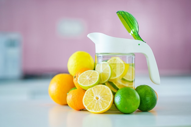 Cruche en verre avec de l'eau de citron détoxifiante infusée rafraîchissante pour une boisson de désintoxication vitaminée.