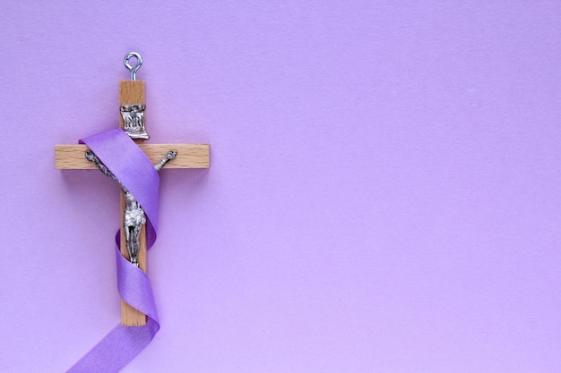 Crucifix en bois religieux chrétien avec ruban violet sur fond violet religion catholique