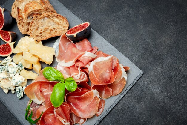 Crudo de prosciutto italien ou jambon espagnol, fromage, figues et pain