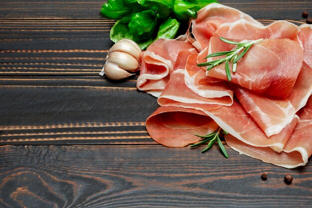 Crudo de prosciutto italien ou jambon espagnol. Jambon cru sur une surface en bois