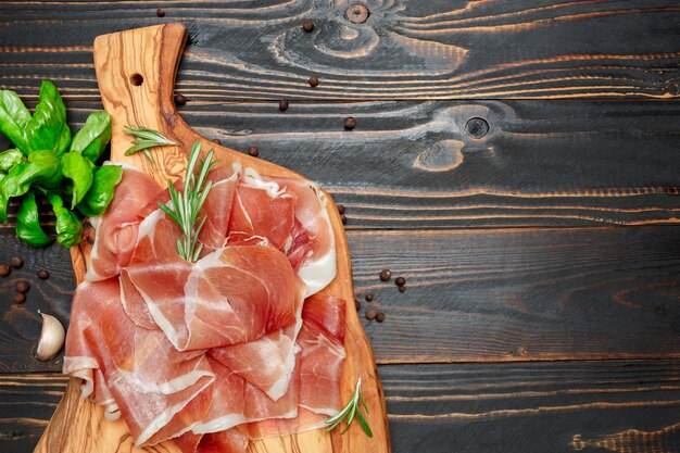 Crudo de prosciutto italien ou jambon espagnol. Jambon cru sur une surface en bois