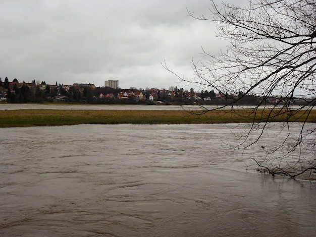 Crue printanière La rivière est sortie de son lit et a débordé Vue d'une petite ville de l'autre côté de la rivière