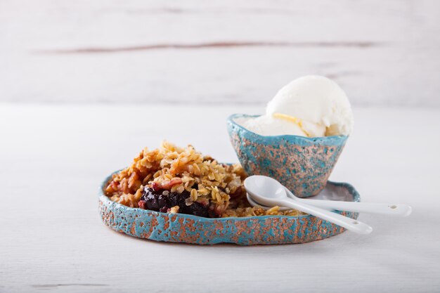 Crumble de prunes avec un cercle de glace blanche.