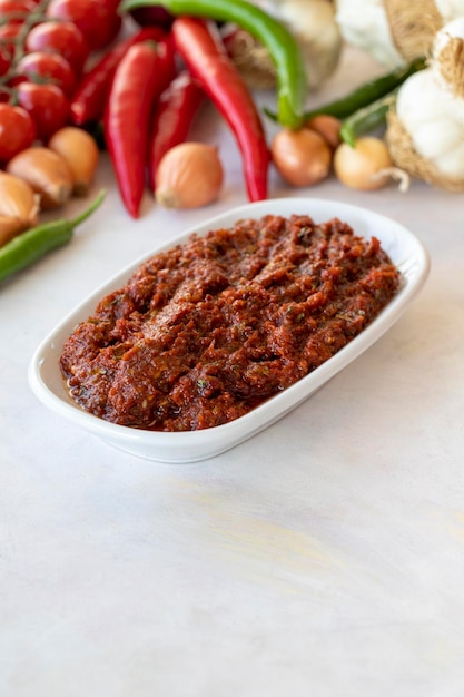 Crush épicé ou adjika apéritif harissa à base de tomate poivron ail oignon pâte de piment et huile d'olive Saveurs de la cuisine traditionnelle du Moyen-Orient Collation végétarienne saine avec plat principal Acili ezme