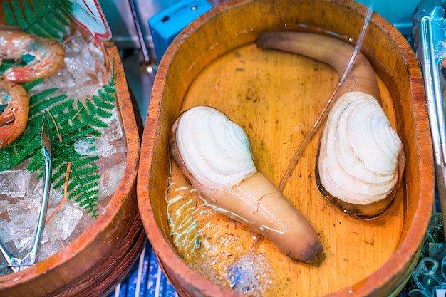 Les crustacés frais au marché aux poissons dans une boîte circulaire en bois prête à être vendue pour la nourriture au Japon