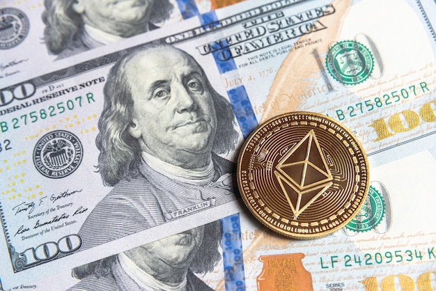 La crypto-monnaie Gold Ethereum en dollars américains. Gros plan sur la crypto-monnaie numérique. Echange, affaires, commercial. Profitez de l'extraction de devises cryptées. Mineur avec des dollars et une pièce d'or ethereum.