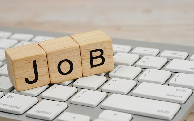 Cube en bois avec le texte JOB sur une recherche d'emploi au clavier et une application en ligne