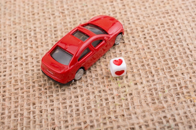 Un cube de cœur sur une voiture de jouet rouge