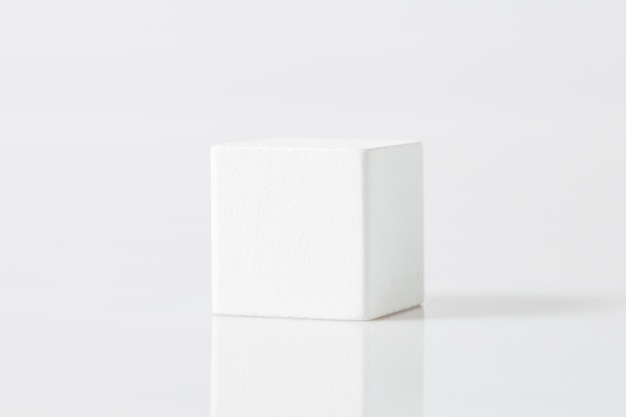 Cube de formes géométriques en bois blanc isolé sur blanc