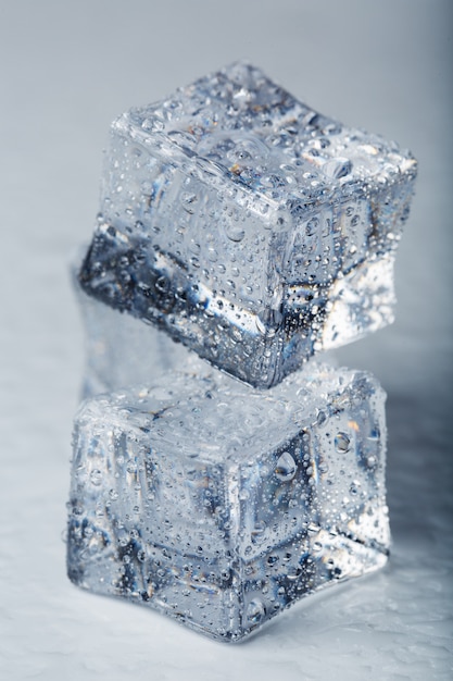 Cube de glace avec des gouttes d'eau close-up en macro sur fond blanc. Glace rafraîchissante. Isoler