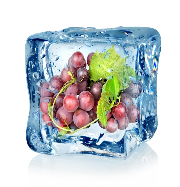 Cube de glace et raisins bleus isolés sur fond blanc