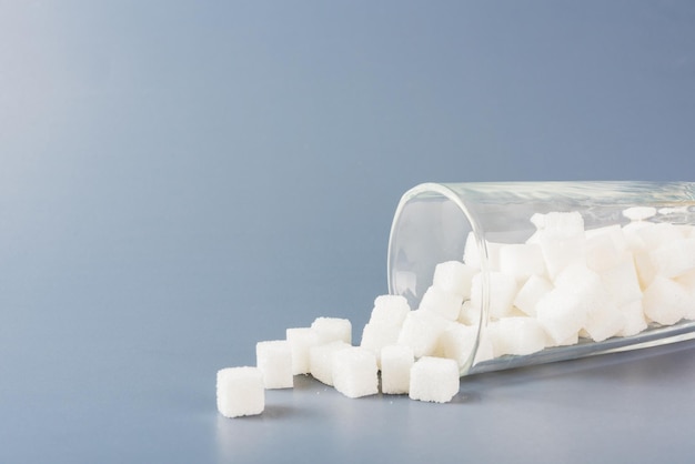 Cube de sucre blanc ingrédient alimentaire sucré renversé hors du verre