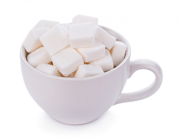 Cube de sucre en tasse sur mur blanc