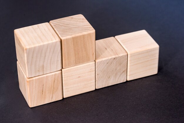 Photo cubes en bois jaunes vides isolés sur fond noir