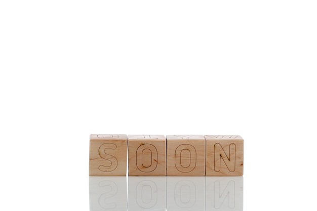 Cubes en bois avec des lettres bientôt sur fond blanc