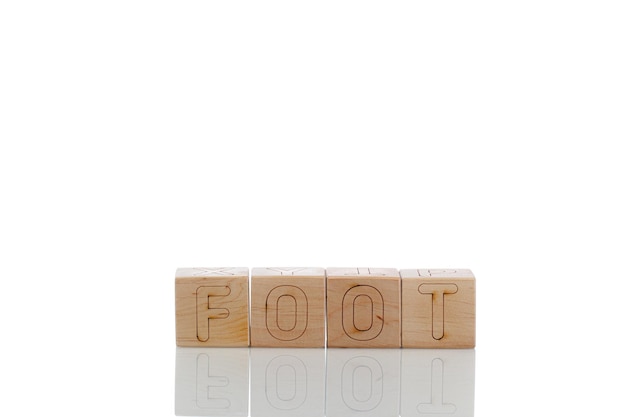 Des cubes en bois avec des lettres pied sur un fond blanc